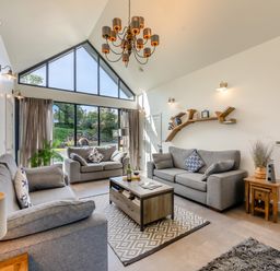 A living room with two gray sofas a coffee table and large windows at Shearwater Lodge in Bamburgh