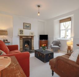 A living room with a sofa and armchair at 84 Fore Street
