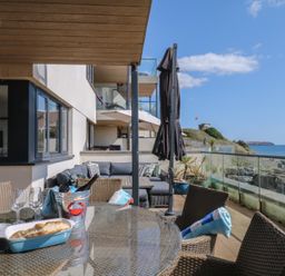 An outdoor seating area with a dining table and sofa at 4 Burgh Island Causeway Bigbury