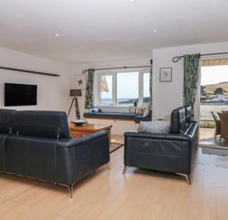 A living room with a sofa and television at 4 Burgh Island Causeway in Bigbury