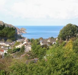 A coastal village with houses and trees overlooking the sea at Linden View in Combe Martin