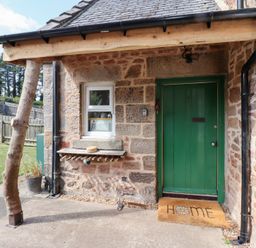An entrance with a green door and welcome mat at Bruno's Bothy Middleton near Belford