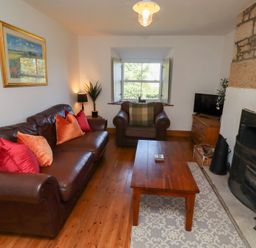 A living room with a sofa and a coffee table at Kits Cottage in Middleton near Belford