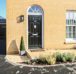 A front door with the number 23 on a yellow brick house with plants by the doorstep at The Hollies in Norwich