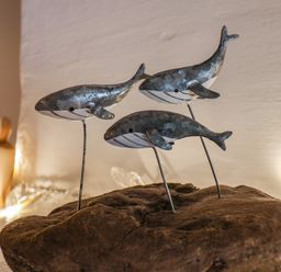 A wooden base with three metal whale sculptures at Lythe Cottage in Lythe