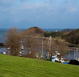 A view of boats in the water with hills and trees at Watermouth Castle, West Tower Apartment Ilfracombe