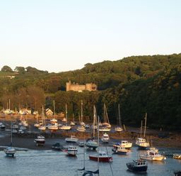 A view of boats on water with a castle in the background at Watermouth Castle, West Tower Apartment, Ilfracombe