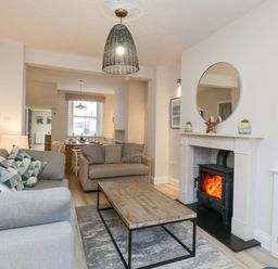 A living room with two sofas a wooden coffee table and a fireplace at Forty Five in Keswick