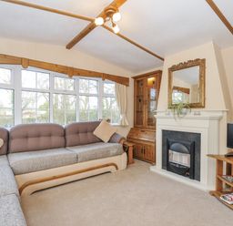 A living room with a sofa, fireplace and television at Little Malory in St Giles-On-The-Heath