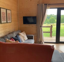 A living room with a sofa and television at Primrose, Higher Wambrook near Chard