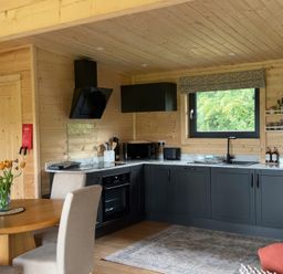 A kitchen with a dining table and a window at Primrose in Higher Wambrook near Chard