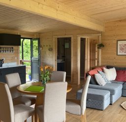 A living room with a sofa and dining area at Primrose in Higher Wambrook near Chard