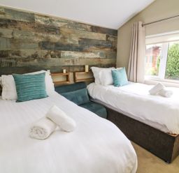 A bedroom with two single beds and a window showing greenery at Lakeside 12 in Carnforth