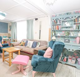 A living room with armchairs a sofa wooden tables and a bookshelf at White Rabbit Cross Lane Eccles-On-Sea