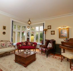A living room with a piano and seating at White House