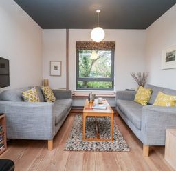 A living room with two sofas and a coffee table by a window at Mundays in Orford