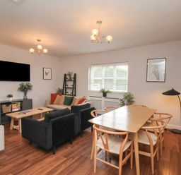 A living room with a television and dining table at The Pheasantry Flamborough