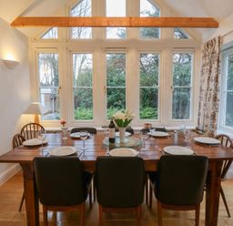 A dining room with a table set for dinner at 9 Church Farm Rise in Aldeburgh