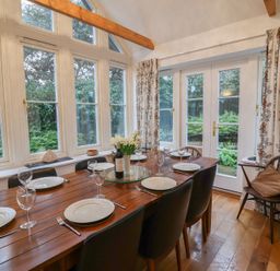 A dining room with a table set for dinner at 9 Church Farm Rise in Aldeburgh