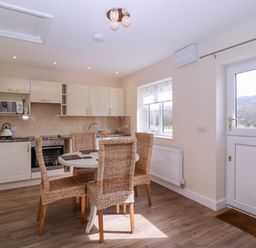 A kitchen with dining table and chairs at Country Cottage Brecon