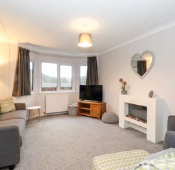 A living room with sofas television and a fireplace at Hill Lodge in Applethwaite 2 Limefitt Park near Windermere