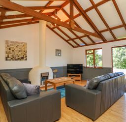 A living room with two sofas facing a coffee table and a television near a fireplace at Bay Tree Lodge 35 in Watermouth near Berrynarbor