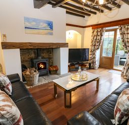 A living room with a fireplace television two sofas and a coffee table at Winding Wheel Cottage in Cambois near Ashington