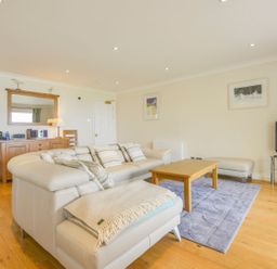 A living room with a white couch and wooden coffee table at 19 Burgh Island Causeway in Bigbury-On-Sea
