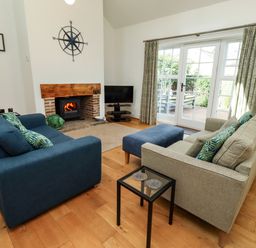 A living room with a fireplace and television at Little Tern Seahouses