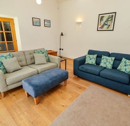 A living room with two sofas and an ottoman at Little Tern in Seahouses