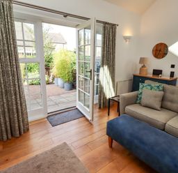 A living room with a sofa and ottoman at Little Tern Seahouses
