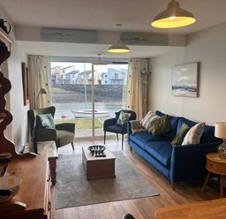 A living room with a sofa and coffee table at 9 Oakley Wharf in Porthmadog