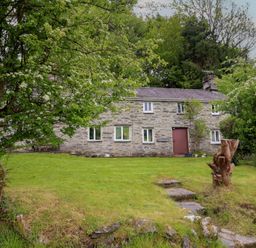 A house with a pathway and trees at The Long House in Penmachno