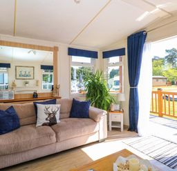 A living room with a sofa, mirror, and plant at 25 Foxburrow Hang in Fritton near Belton