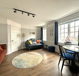 A living room with a sofa and a table at Melanie's Cottage in Brewers Quay Harbour