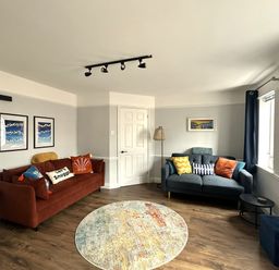 A living room with sofas, a rug and wall art at Melanie's Cottage Brewers Quay Harbour