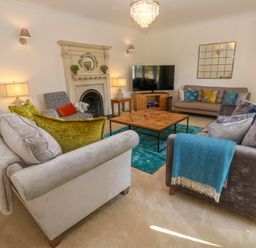 A living room with sofas cushions coffee table fireplace and television at Hindon Hall in Lelant near Carbis Bay