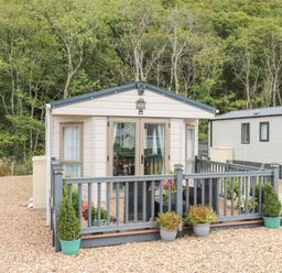 A holiday home with decking and flower pots at The Haven in 
