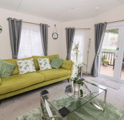 A living room with a green sofa and glass table at The Haven