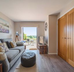 A living room with a sofa and television at Piglet Corner in Culmstock