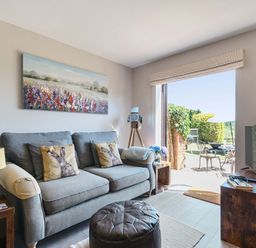A living room with a sofa and television at Piglet Corner in Culmstock