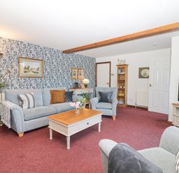 A living room with a sofa armchair coffee table and TV at Woodland View in Muddiford near West Down