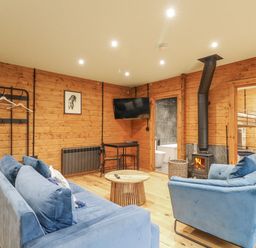 A living room with a sofa, armchair, and television at Otter's View South Luffenham near Edith Weston