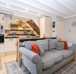 A kitchen with a sofa and kitchenette at Pine Cottage Dinas Dinlle