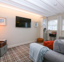 A living room with a television and sofa at Pine Cottage in Dinas Dinlle