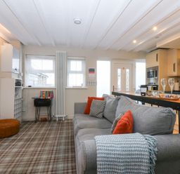 A living room with a couch and table at Pine Cottage in Dinas Dinlle