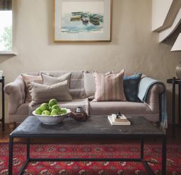 A living room with a sofa pillows and lamps on side tables at Hawthorn Cottage at Collihole in Chagford
