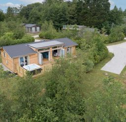 A wooden house with opened doors and a hot tub on the deck surrounded by trees at 5 Southern Place in Dobwalls