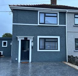 The exterior of a two-story semi detached house with a driveway and dark door at Swn Y Mor in Burry Port