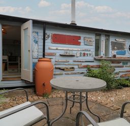 An outdoor area with a studio and seating at The Artist's Cabin By The Sea in Herne Bay